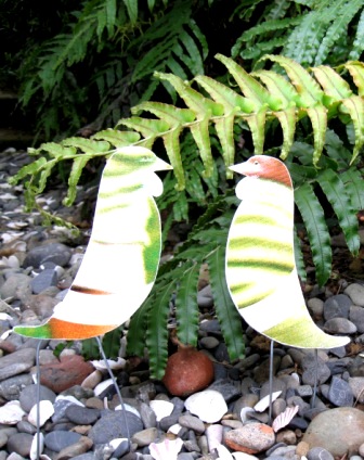 Recycled coreflute tui birds with stilt legs for amusement in the garden.
